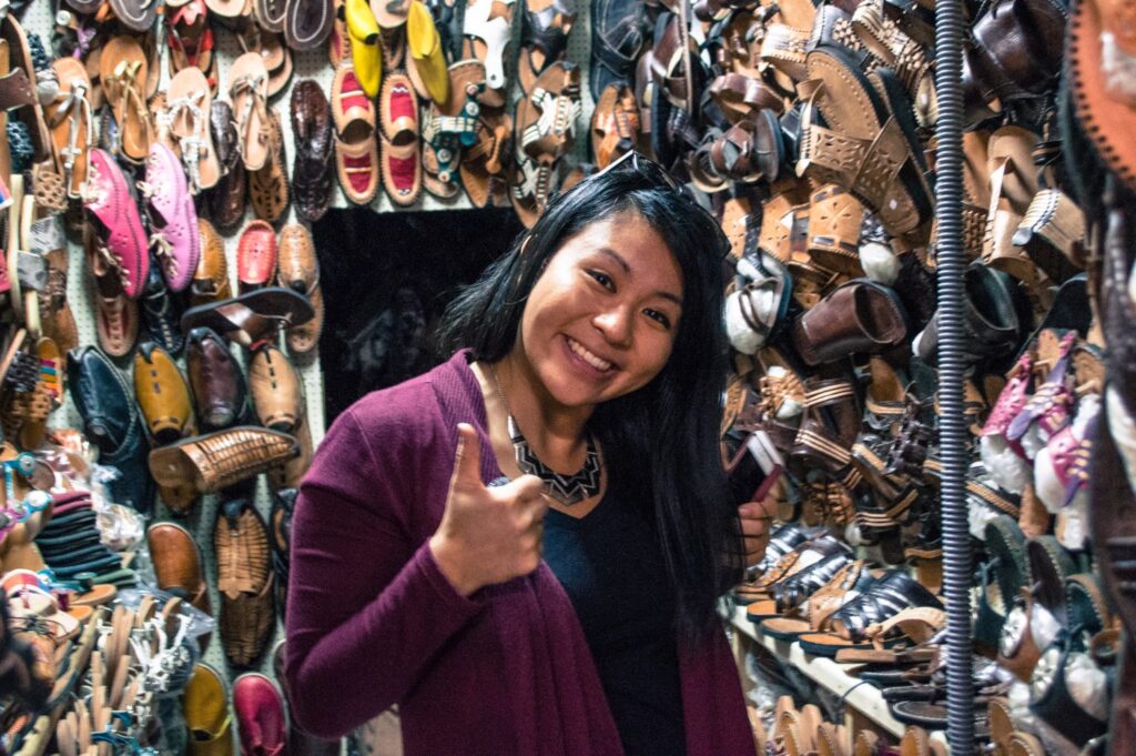 Girl in Moroccan market next to a shoe stand