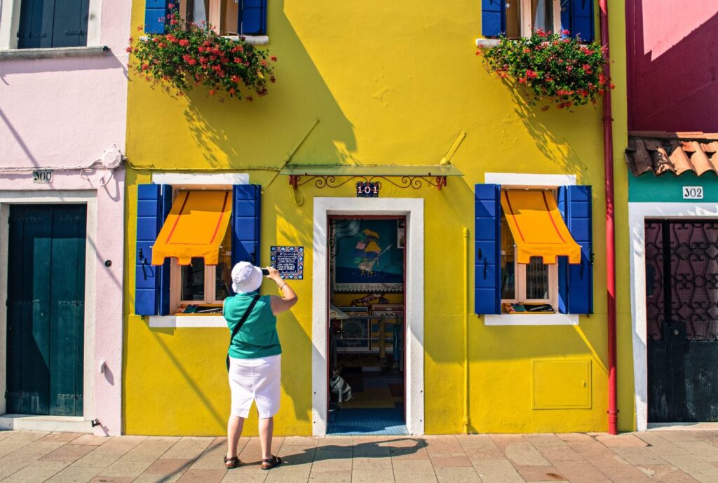 Yellow house with blue shutters in Burano Italy