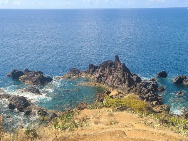 A view high above the ocean with rocky cliffs against turquoise water