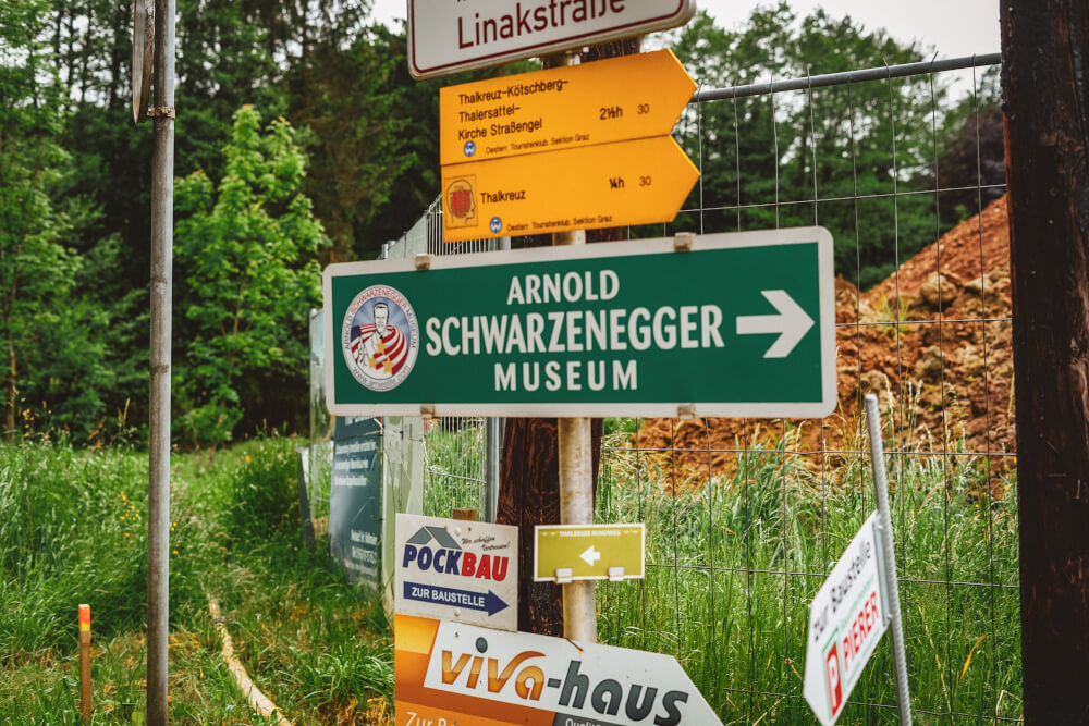 Street signs leading to the Arnold Schwarzenegger Museum in Thal, Austria