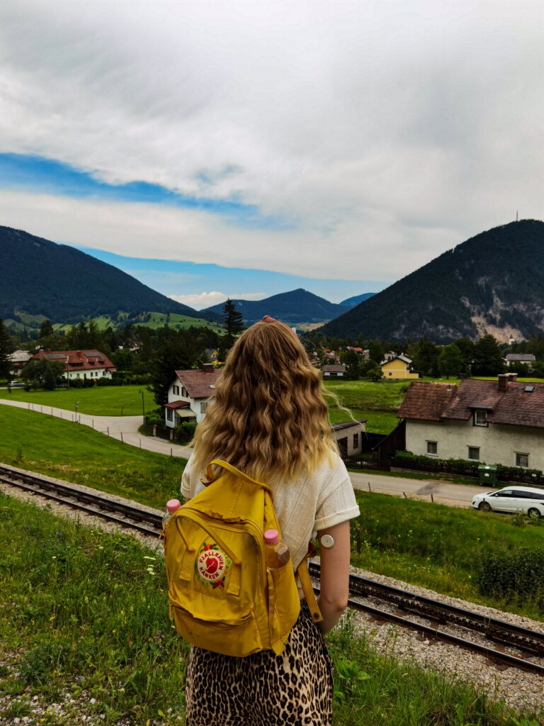 Girl with yellow backpack travelling in the Austrian countryside