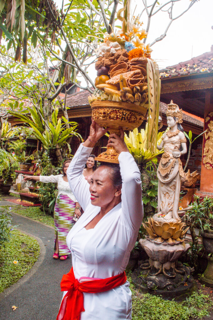 Balinese woman holding fruit offering above her head
