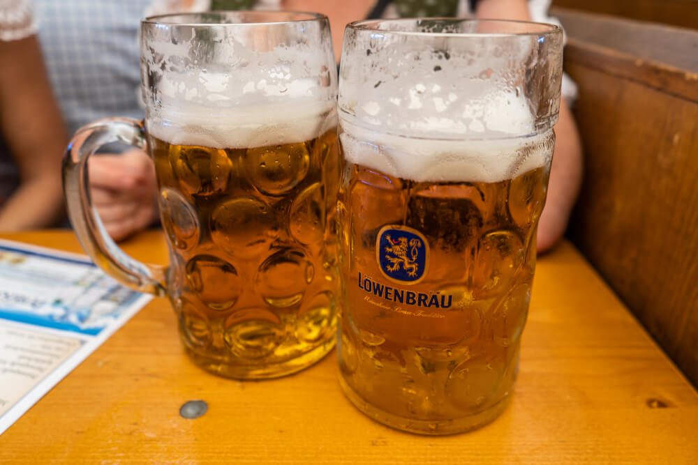 1L Löwenbräu beers on a wooden table at Oktoberfest.