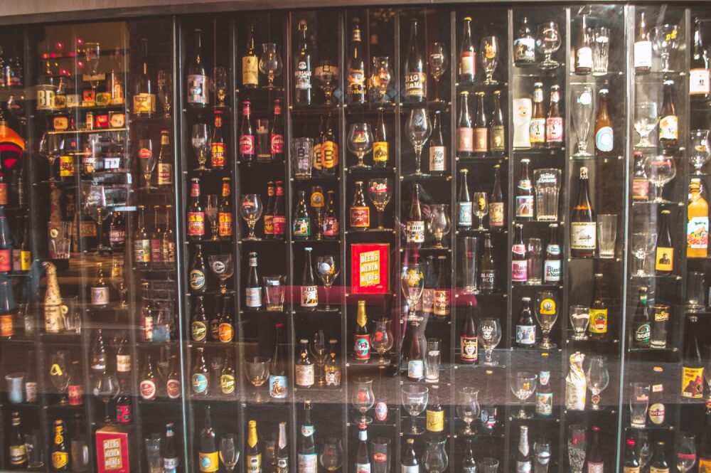 Wall full of different beers and beer glasses in Bruges, Belgium