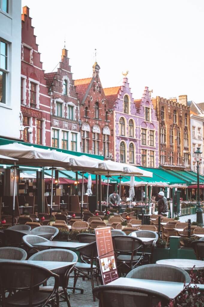 Market Square in Bruges with empty terraces at sunrise