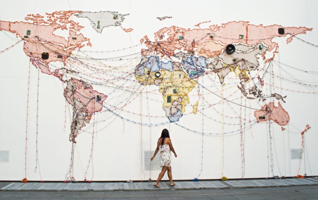 Girl walking in front of a world map installation