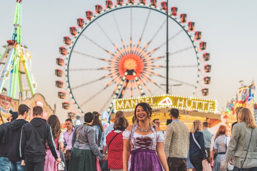 Christina Guan wearing a custom dirndl in front of the ferris wheel at Oktoberfest in Munich, Germany