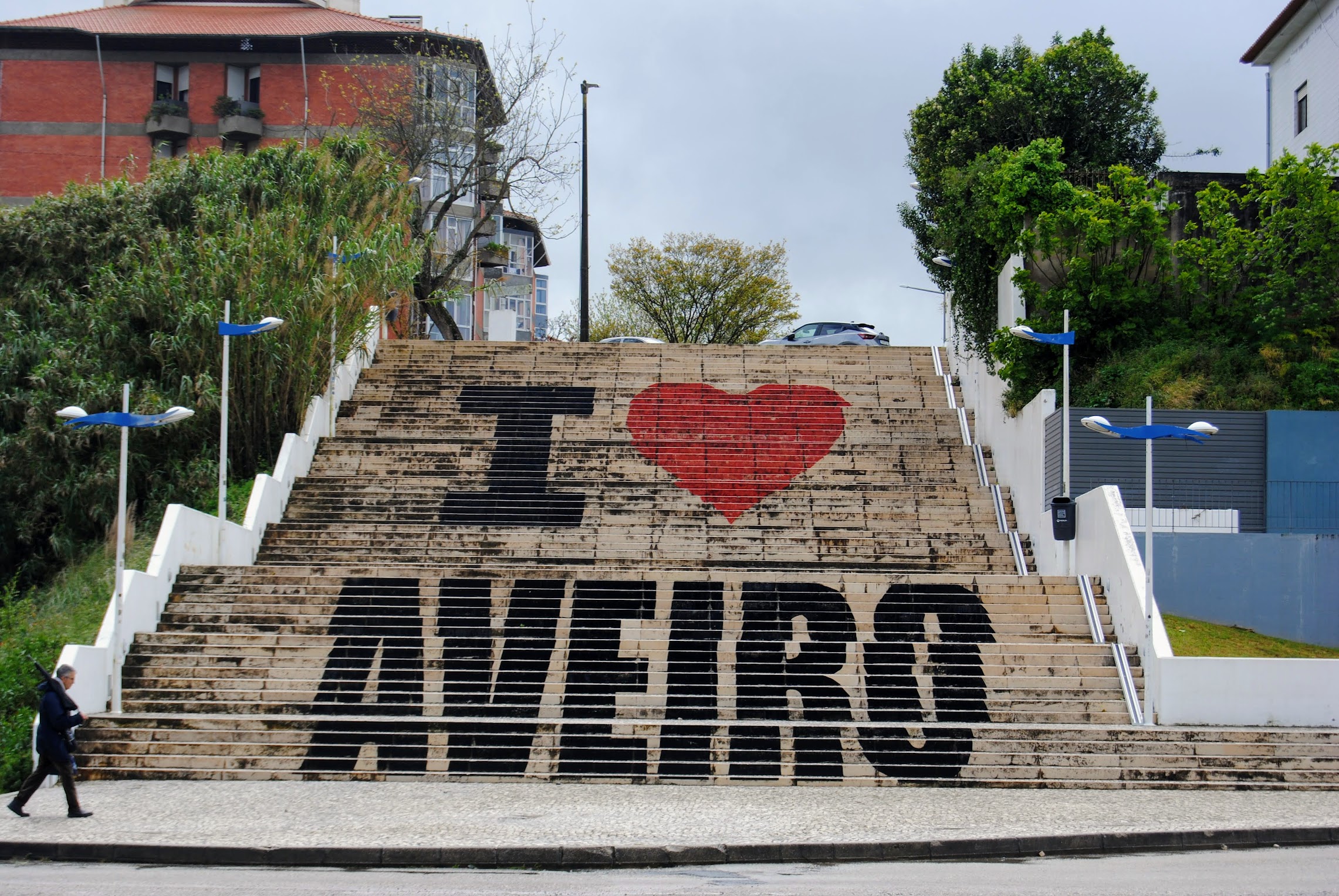 A man walking next to stairs that say "I love Aveiro"