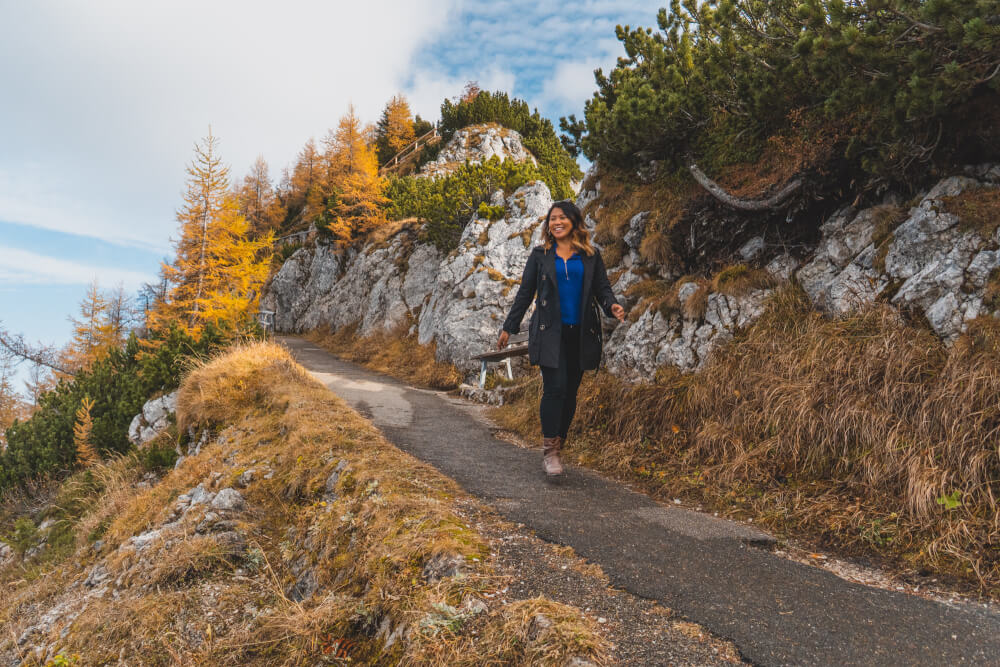 Girl walking down mountain path surrounded by Fall foliage