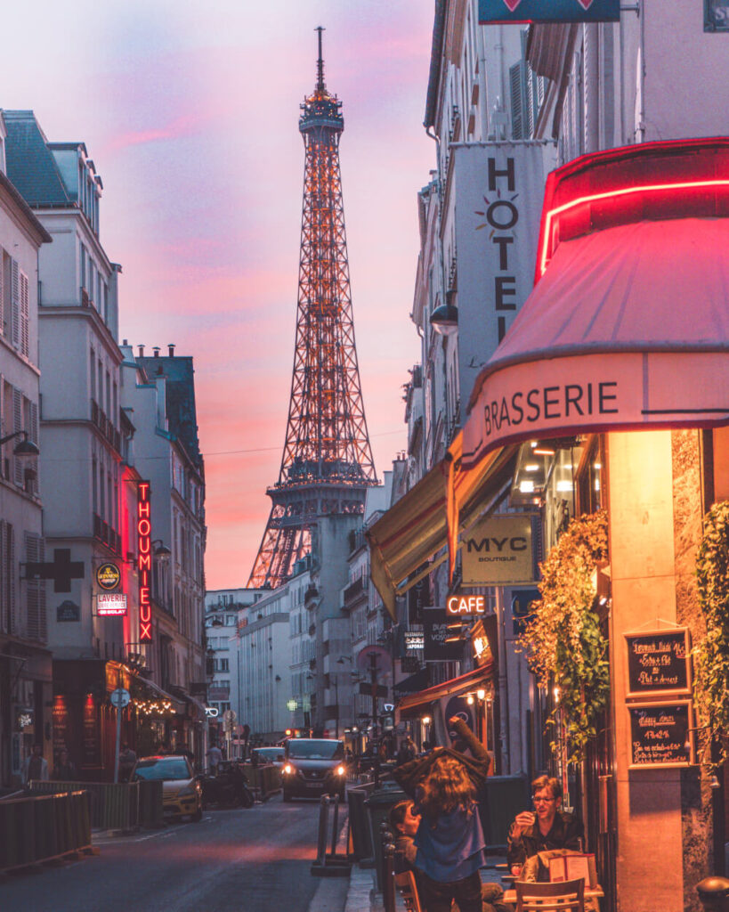 Typical Parisian street with the Eiffel Tower in the background with a pink sunset