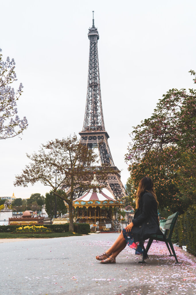 Travel blogger sitting on a bench by the Eiffel Tower