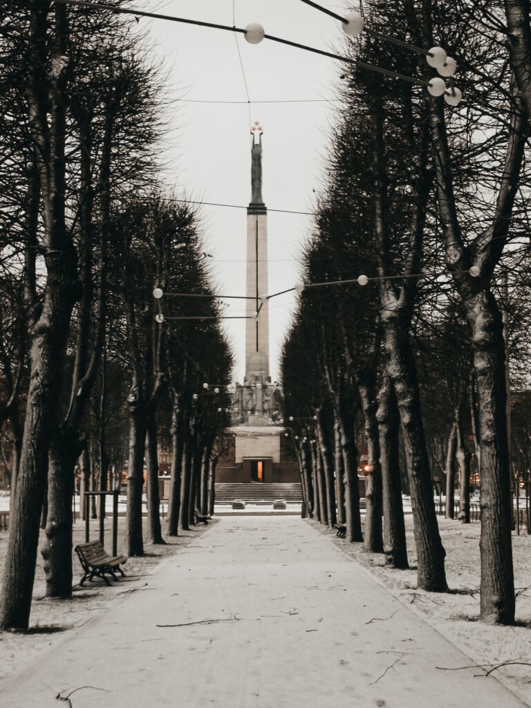 Freedom monument in Riga behind snowy trees