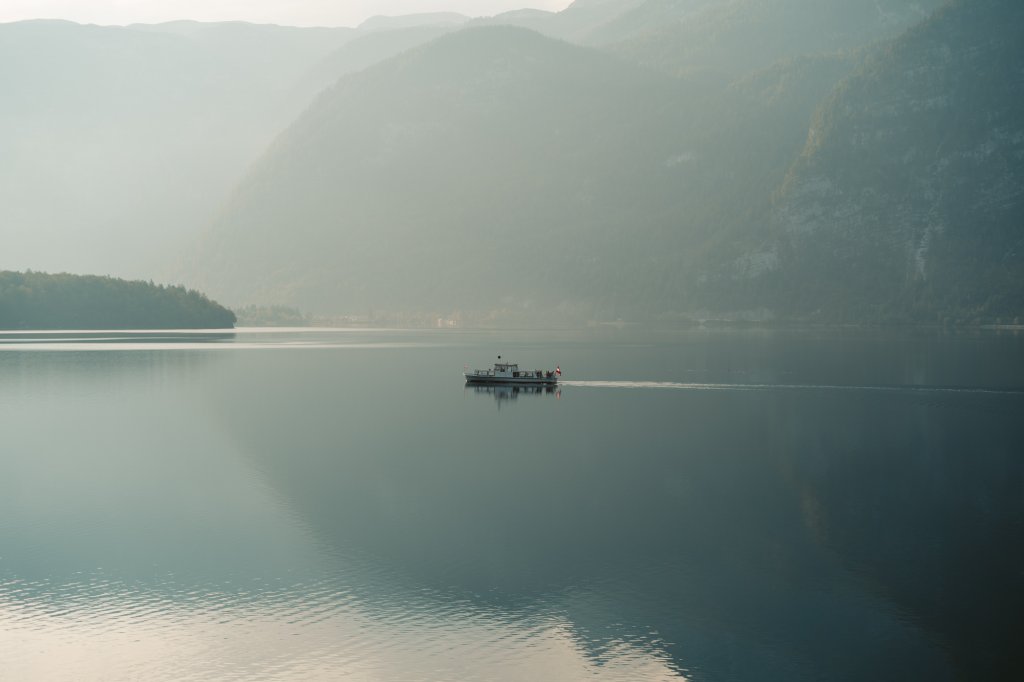 A boat gliding across the lake at Hallstatt, Austria in the early hours of the morning.