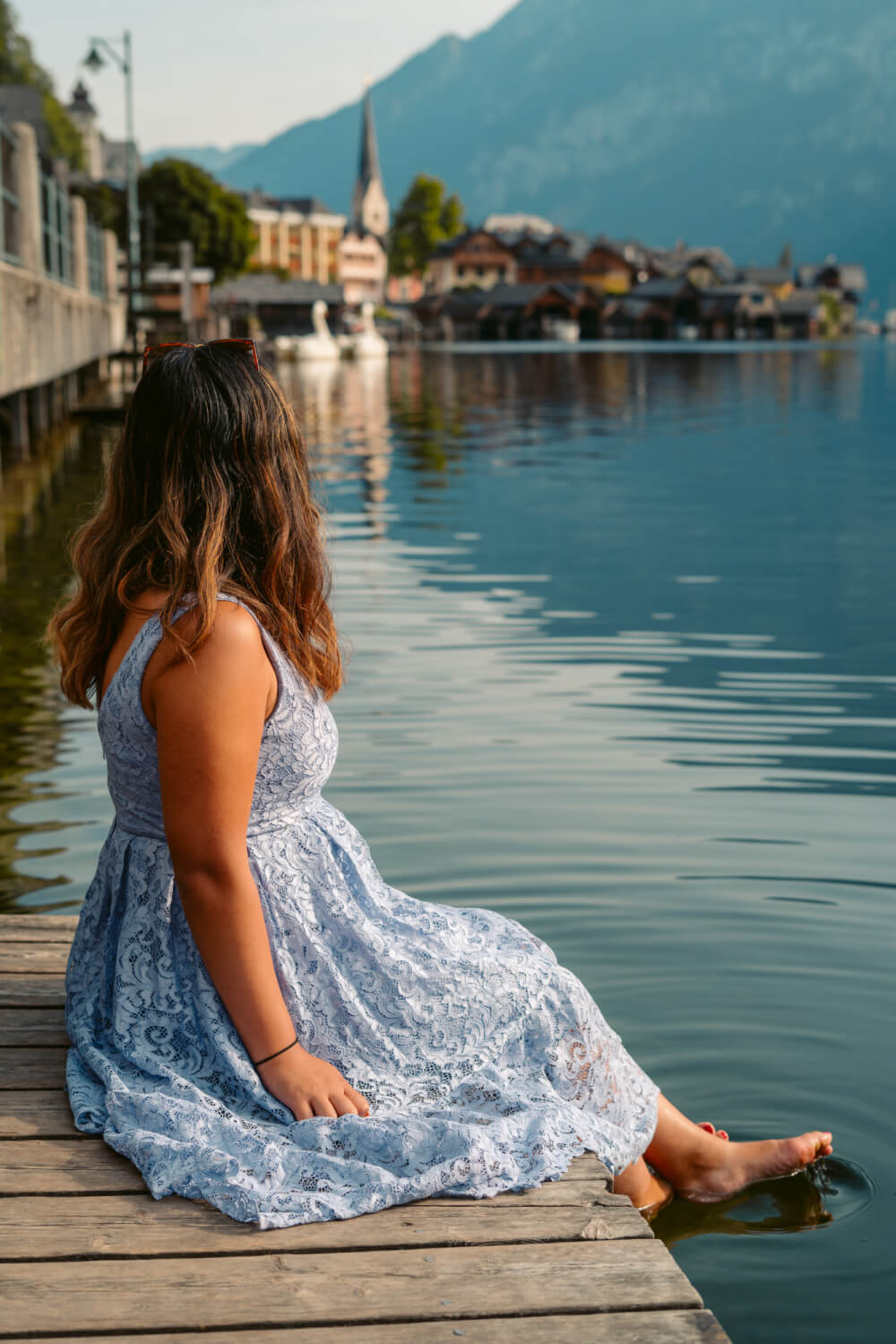 Travel blogger Christina Guan from Happy to Wander by the lake in Hallstatt, Austria.