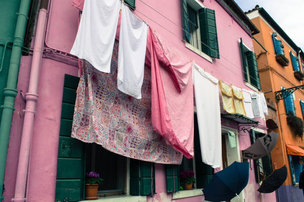 Laundry and umbrellas hanging in Burano Italy