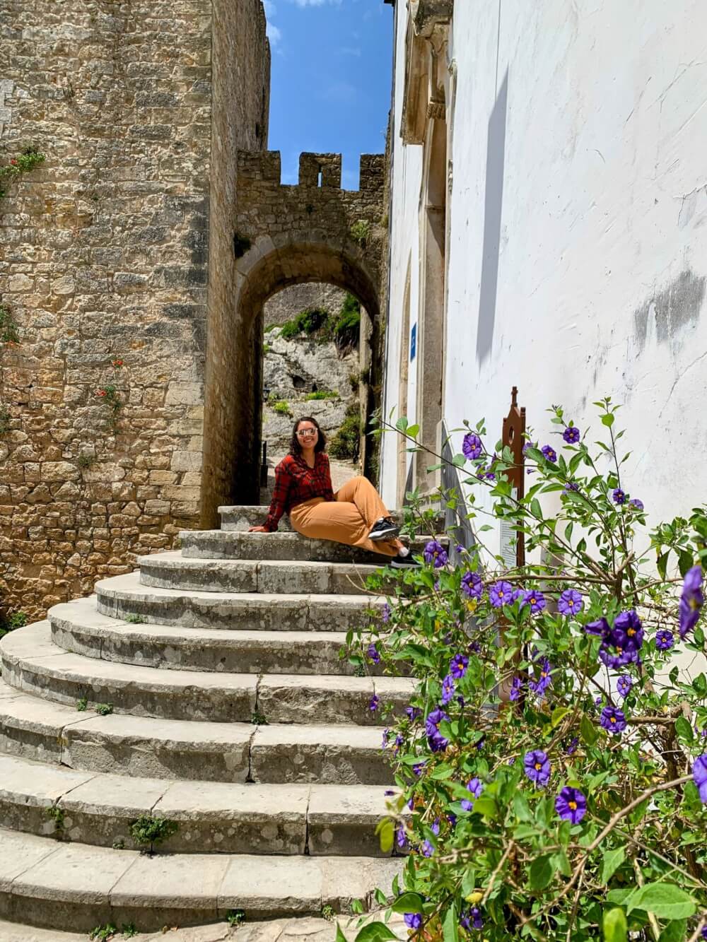 A person sitting on a step in front of a castle entrance