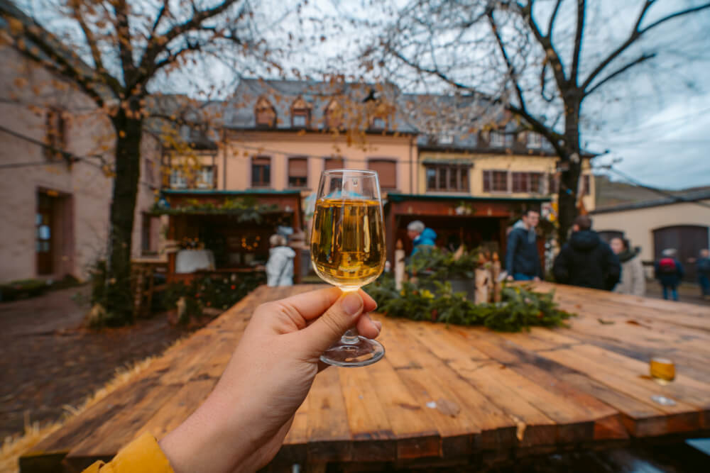 Glass of wine held out at a Christmas market in Kaysersberg, France