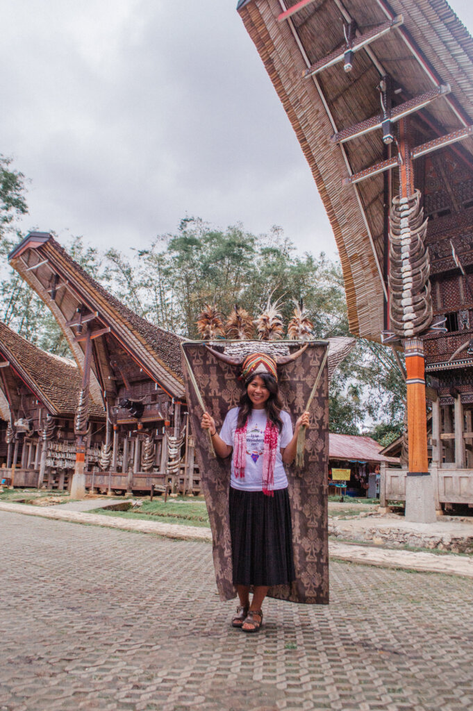 Girl in Kete Kesu holding a traditional head dress used for dance