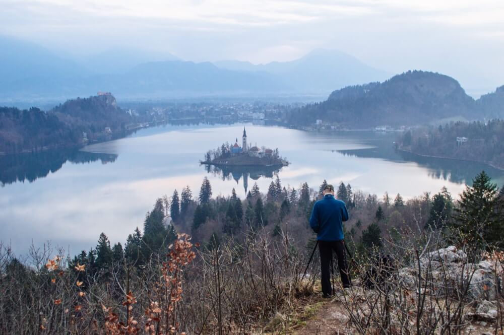 How to get the BEST view of Lake Bled, Slovenia at sunrise. This guide shows you how to hike to this gorgeous viewpoint of Lake Bled and gives you practical advice on how to find the trail head and more!