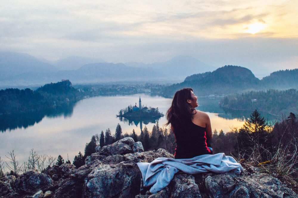 How to get the BEST view of Lake Bled, Slovenia at sunrise. This guide shows you how to hike to this gorgeous viewpoint of Lake Bled and gives you practical advice on how to find the trail head and more!