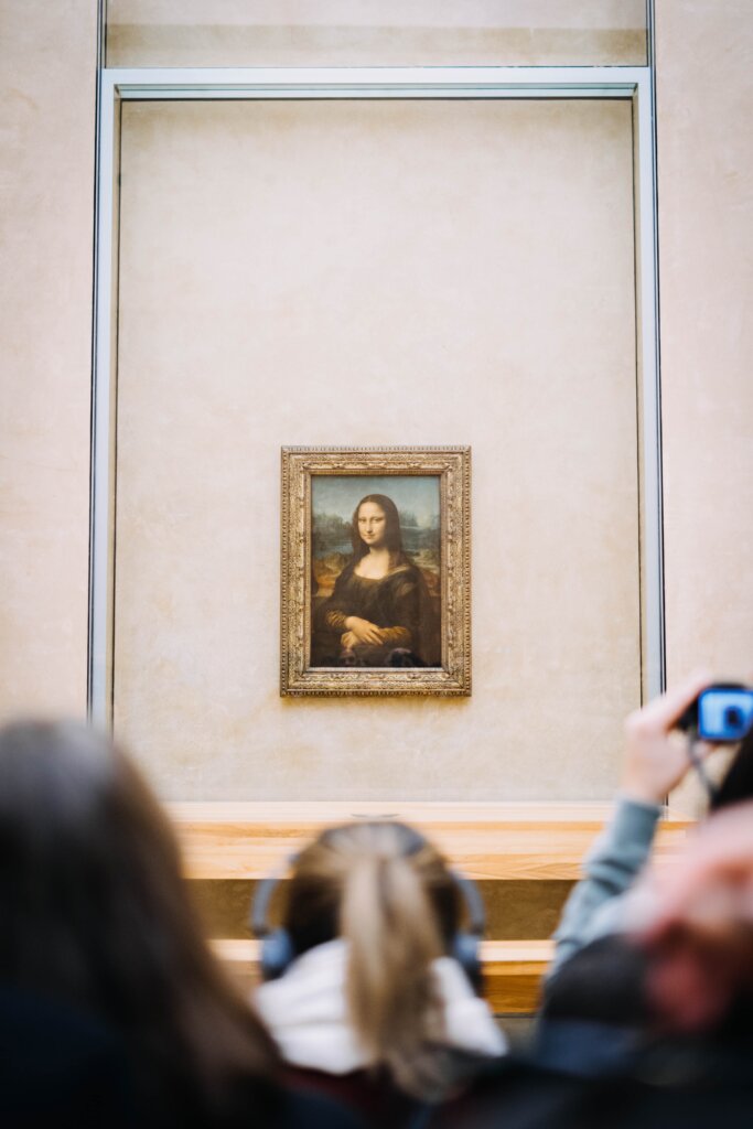 Tourists photographing the Mona Lisa at the Louvre Museum in Paris, France