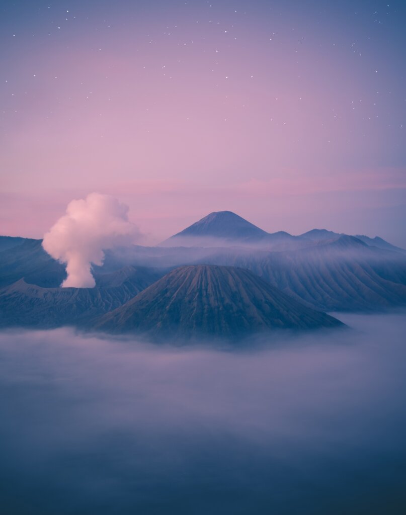 Pink sunrise views over foggy Mount Bromo in Indonesia