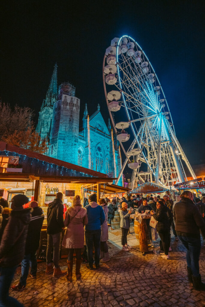 Ferris wheel and cathedral at Mulhouse Christmas Market in France