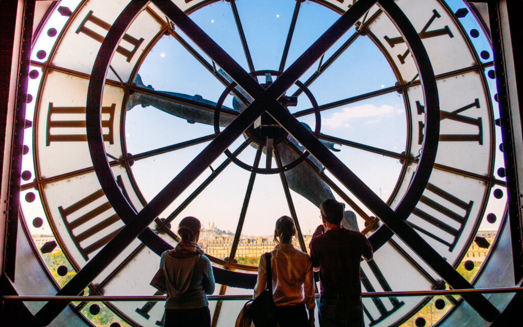 Tourists admiring the clock face in the orsay Museum of Paris, France