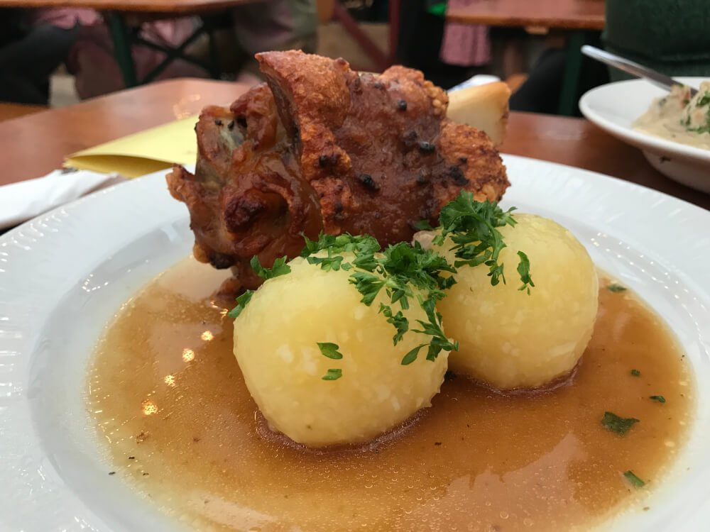 Roasted pork knuckle with potato dumplings at Oktoberfest in Munich, Germany.