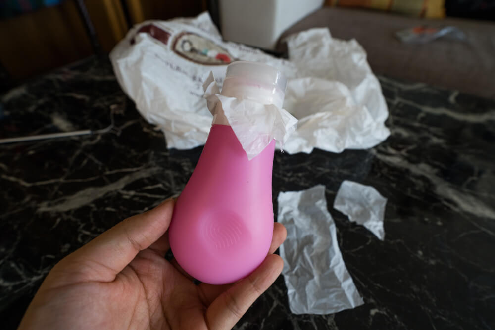 Reusable toiletry bottle with plastic sheet covering it