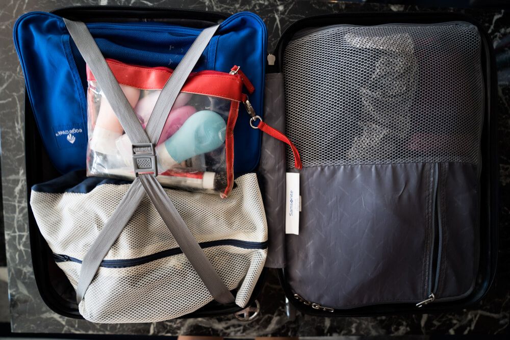 Open packed suitcase with packing cubes and a bag filled with toiletries