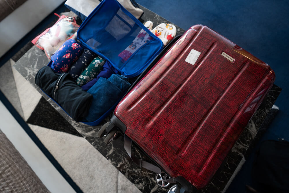 Suitcase and packing cubes on a black marble table