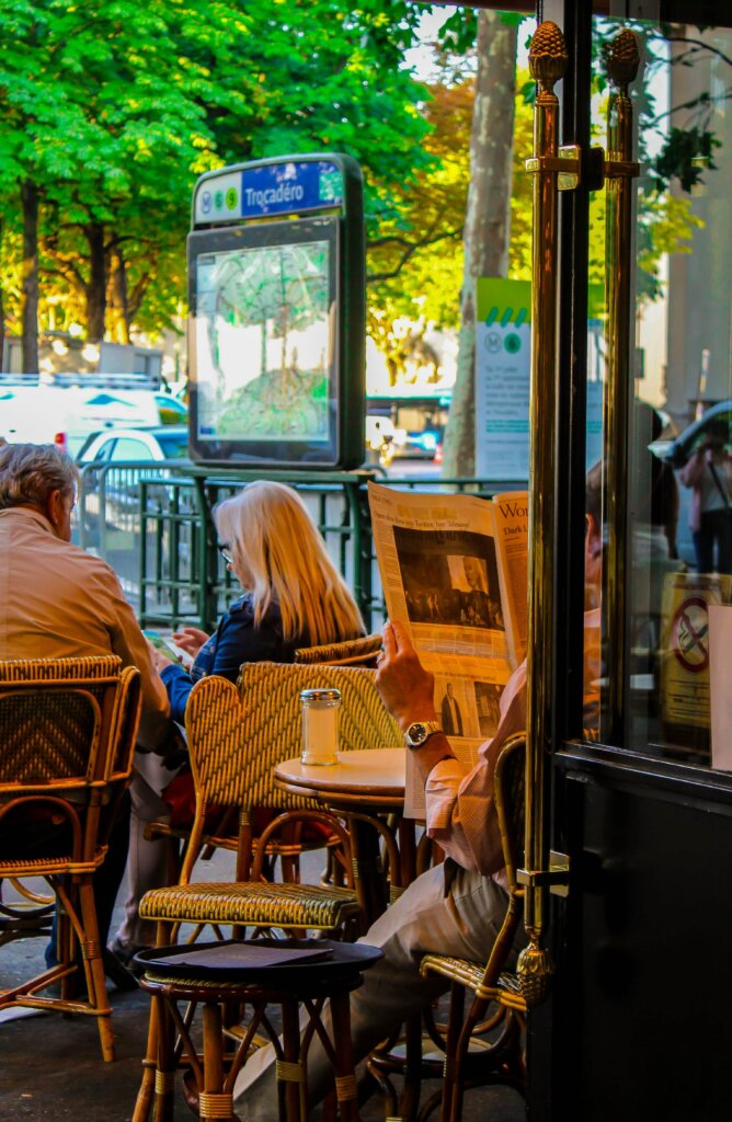 Man reading newspaper at Parisian cafe