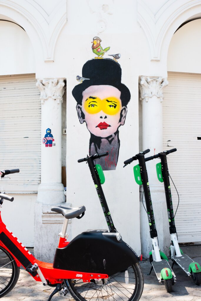 Lime scooters in paris in front of a street mural