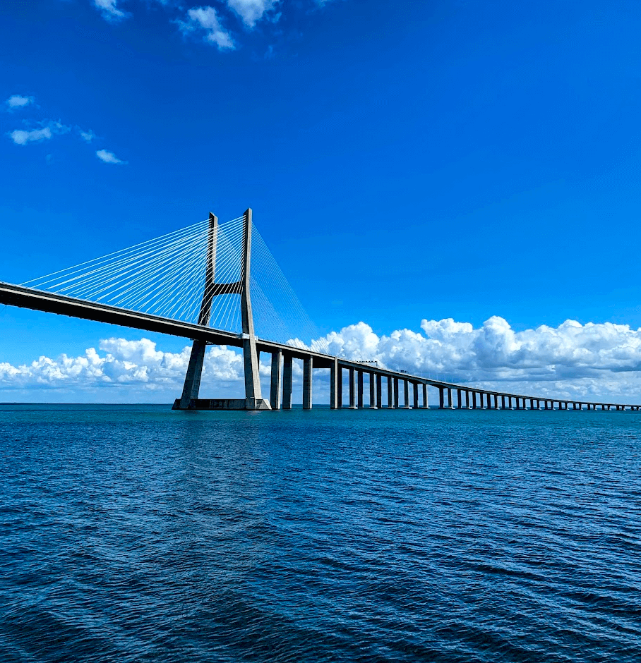 A long grey bridge over blue ocean