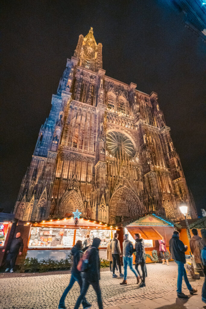 Strasbourg Cathedral at night with Christmas market stalls in front 