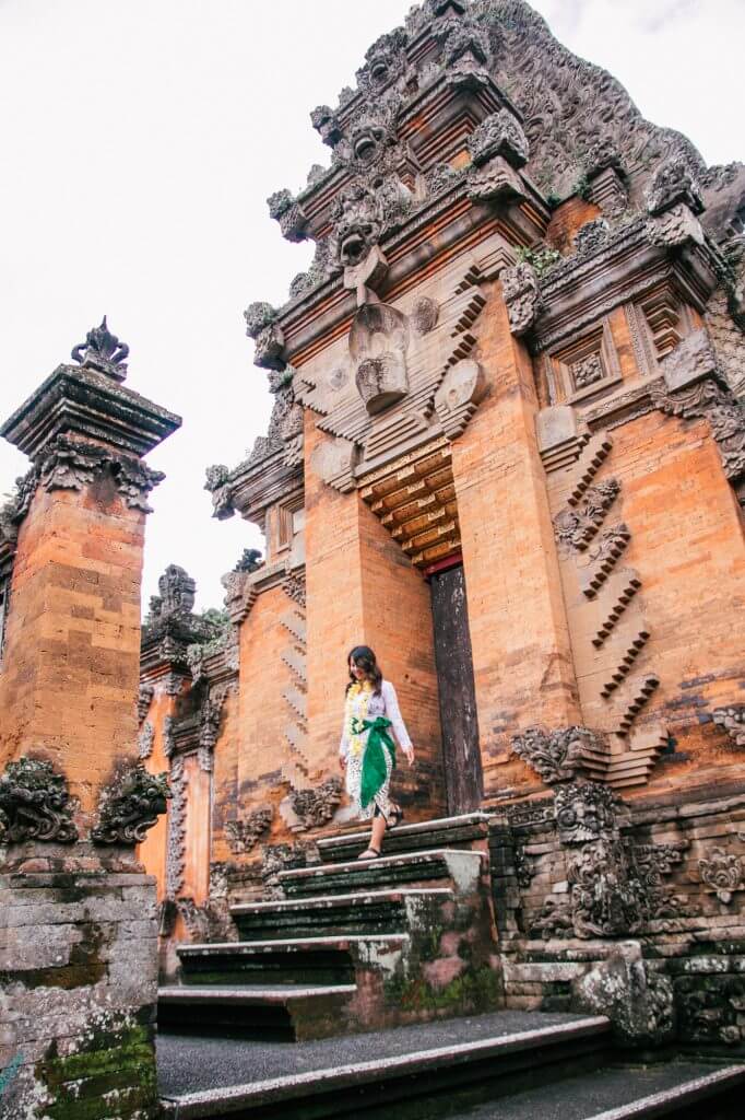 Girl wearing traditional Balinese clothes at a temple in Ubud, Indonesia