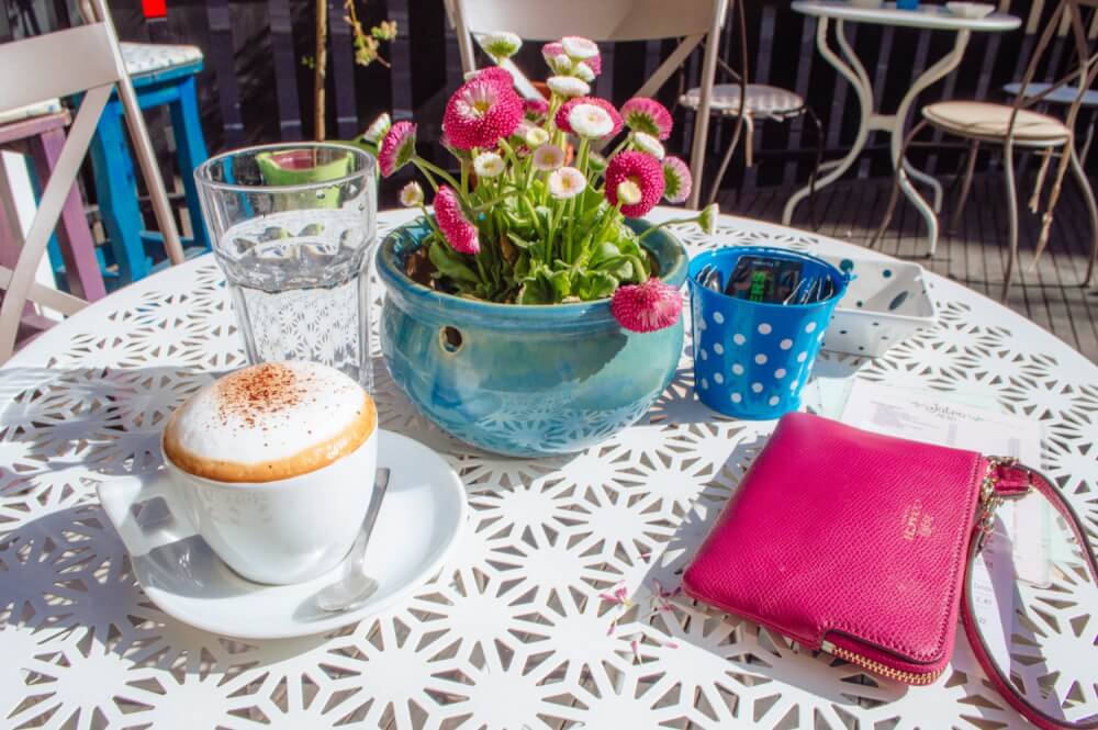 Coffee and wallet on a table at JUTRO Cafe in Zagreb, Croatia