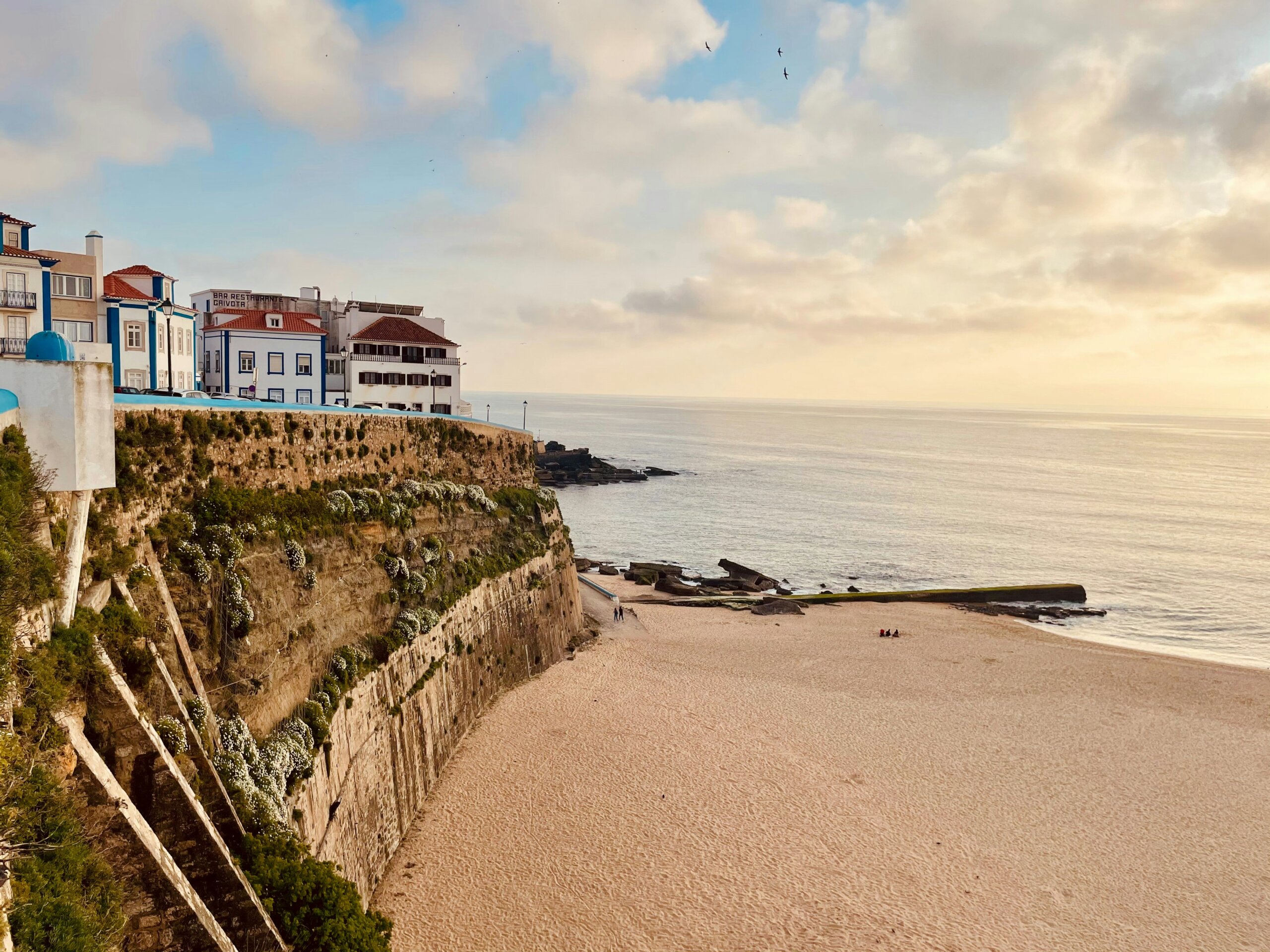 White houses on top of a cliff next to a beach