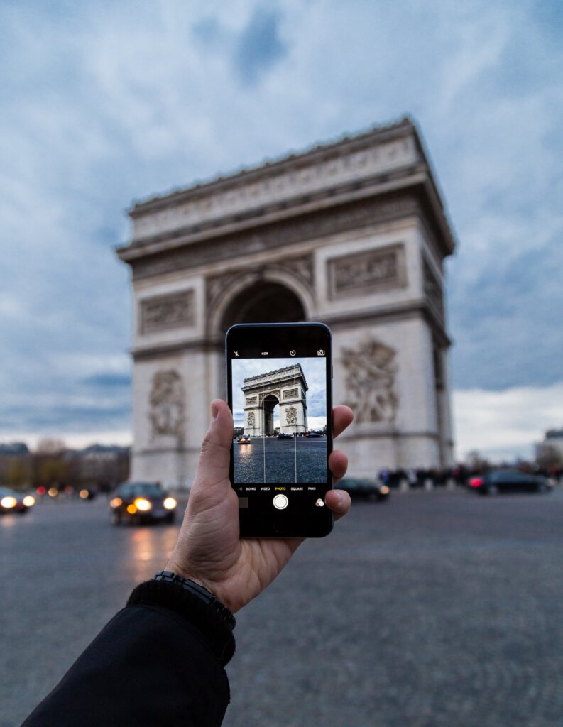 Tourist taking a photo of the Arc de Triomphe