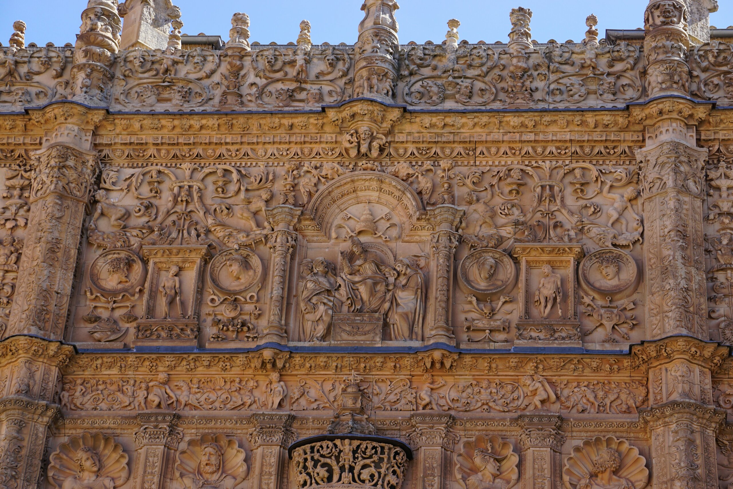 A building facade with intricately carved people, animals, and skulls