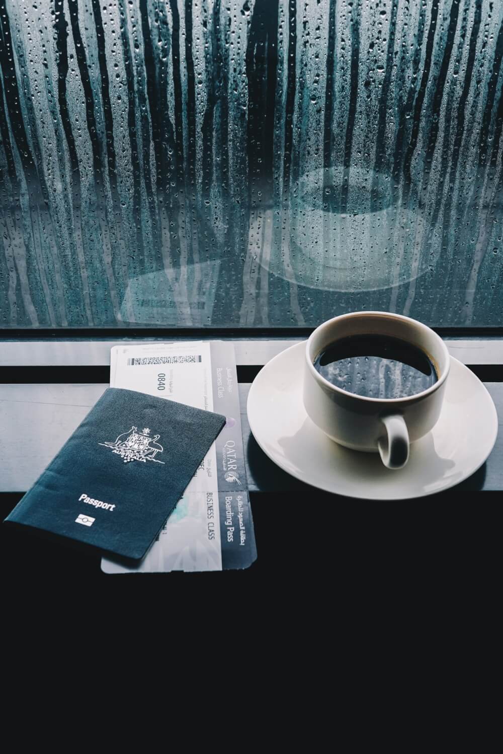 Passport and boarding pass with coffee at airport