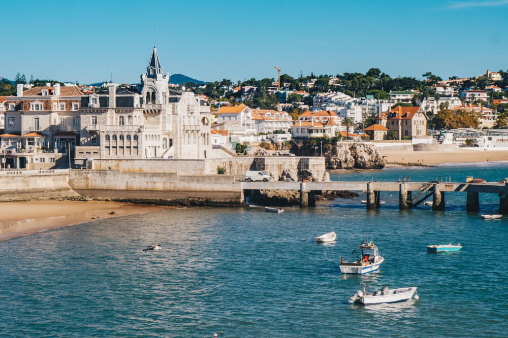 A European seaside village with boats in a harbor and a cathedral