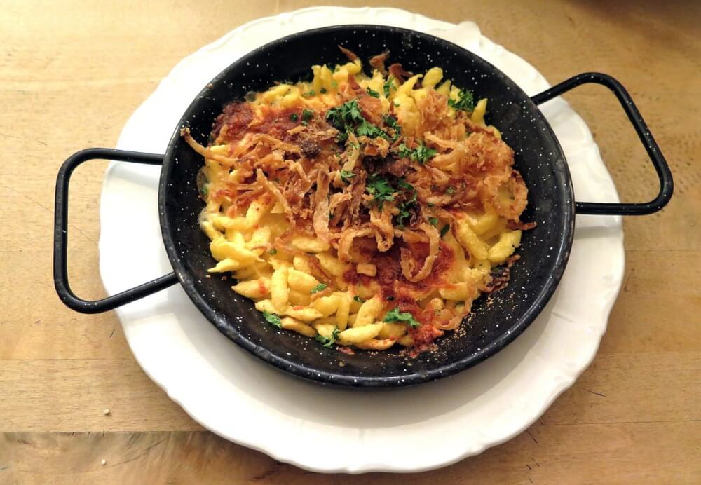 A tasty plate of Bavarian käsespätzle topped with fried onions.