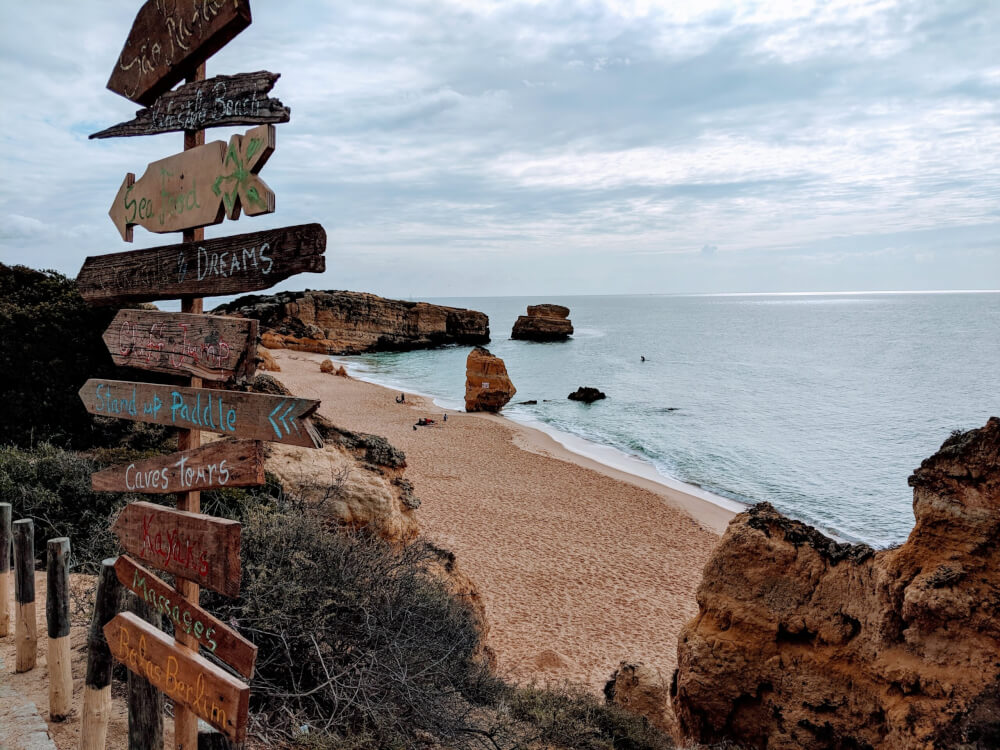 Rocky cliff with signs pointing to caves, paddle tours, and massages