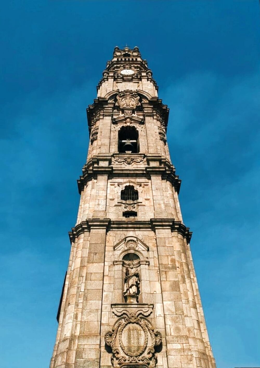 A stone church tower decorated with angels and church bells