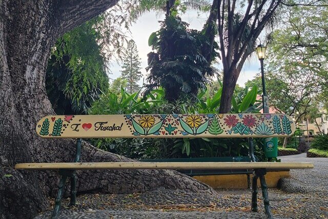 A park bench with plants and "I love Funchal" painted on the back