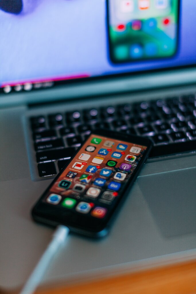 A closeup of a phone being charged on a laptop