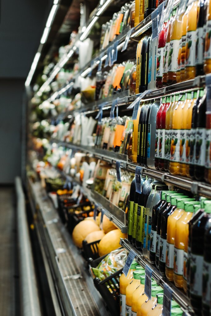 Il corridoio fresco in un supermercato con frullati e insalate in mostra