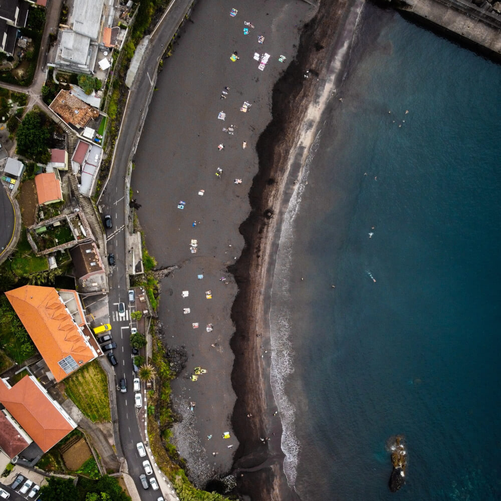 A drone shot of a black sand beach from above